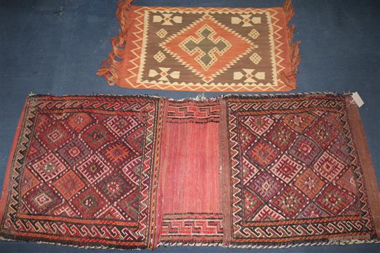 A Belouchi red ground saddle bag and an Indonesian terracotta ground small fringed rug